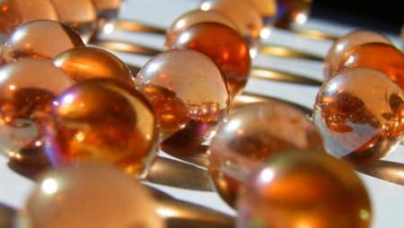 Marbles with sunlight reflecting into them on a white surfaceの写真素材