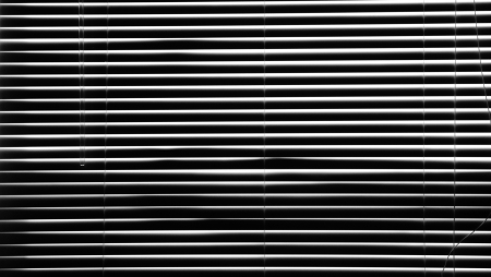 Blinds with a lopt of light trying to shine throughの写真素材