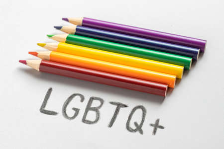 Word LGBT and color pencils on white background, flat lay. Space for textの写真素材