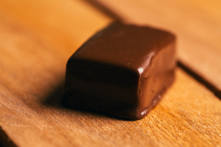 One chocolate candy on a wooden background.の写真素材