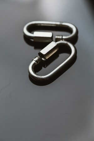 two metal carabiner clip on a dark background.の写真素材