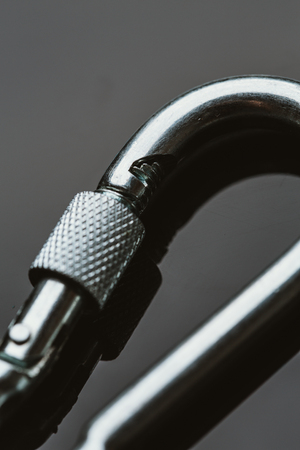 one metal carabiner on a dark mirroring background.の写真素材