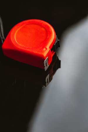 orange construction tape measure against a dark background.の写真素材