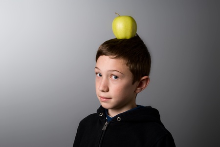 boy with a green apple on his headの写真素材