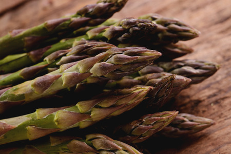 Bunch of fresh asparagus on wooden tableの写真素材