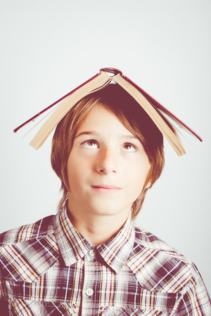 child with a book over headの写真素材