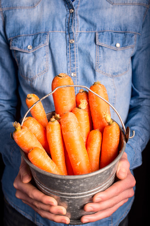 carrots bucket in hands - vegetarian and vegan peopleの写真素材