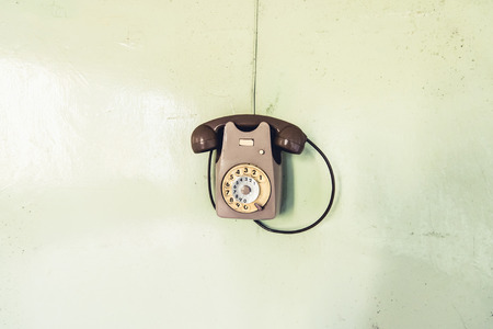 vintage phone on the wall - objects and places lost in timeの写真素材