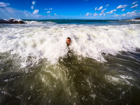 teenager having fun in the sea waves - summertime - Sicily mediterranean seaの写真素材