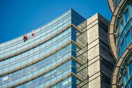 MILAN, ITALY - SEPTEMBER 19,2017: Climber workers for glass cleaning at Porta Garibaldi district, Piazza Gae Aulenti.のeditorial素材