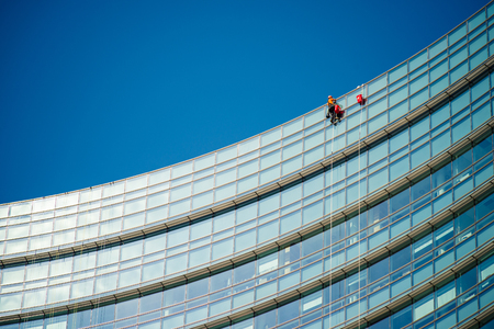 MILAN, ITALY - SEPTEMBER 19,2017: Climber workers for glass cleaning at Porta Garibaldi district, Piazza Gae Aulenti.のeditorial素材