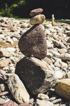 zen stones in equilibrium pyramid at a pebble river beach - concept of equilibrium with nature