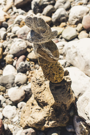 zen stones in equilibrium pyramid at a pebble river beach - concept of equilibrium with nature