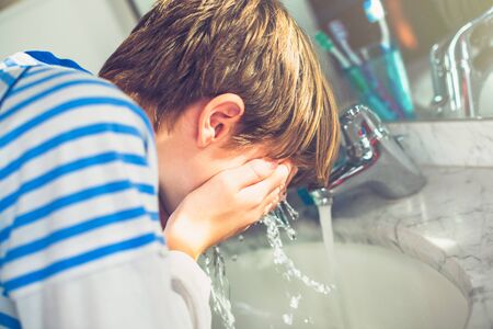 Boy wash his face in the bathroom New day of ordinary lifeの写真素材
