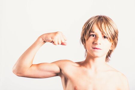 Young boy showing his biceps strength Healthy body concept Fitness teenagerの写真素材