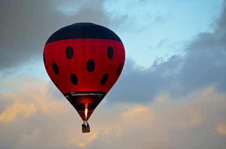 Hot air balloon flying low over St Neots early evening.のeditorial素材