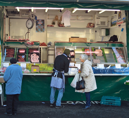 Customers being served from a meat wagon on St Ives Market.のeditorial素材