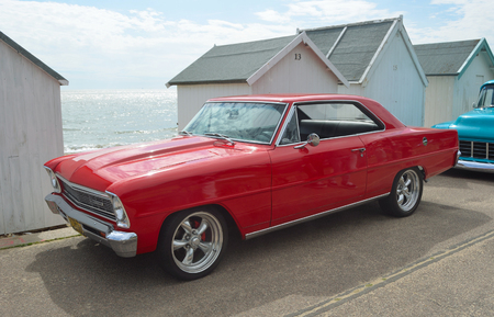 Classic red Chevrolet Chevy II motorcar on Felixstowe seafront.のeditorial素材