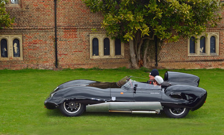 Classic Black Lotus racing car in front of old building.