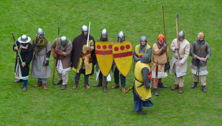Medieval men at arms being drilled by knight.