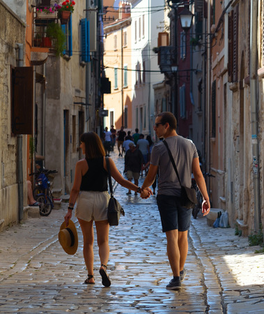 ROVINJ, ISTRIA, CROATIA - JUNE 18, 2017: Young couple walking hand in hand through the streets of the old town Rovinj  Istria Croatia.のeditorial素材