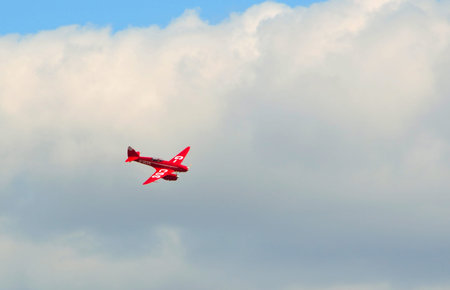 OLD WARDEN, BEDFORDSHIRE, ENGLAND - AUGUST 06, 2017:  DH88 De Havilland Comet  flying  Cloudy Sky.