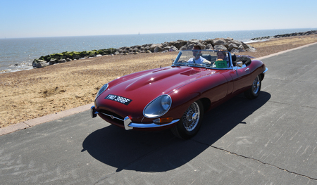 FELIXSTOWE, SUFFOLK, ENGLAND -  MAY 07, 2017: Classic Red Jaguar  E  Type Convertible Motor Car being driven along Seafront Promenade.のeditorial素材