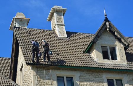 CASCAIS, PORTUGAL - MARCH 08, 2016: Abseiling building maintenance workers at work.のeditorial素材