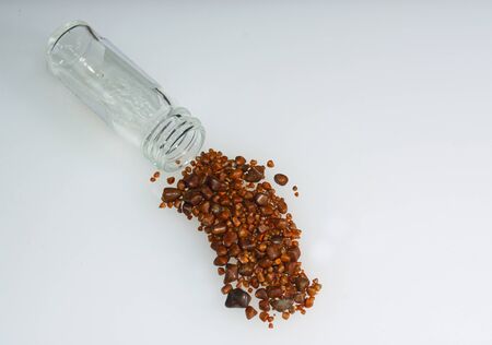 Gallstones and specimen jar, stones from single operation on white background.の写真素材