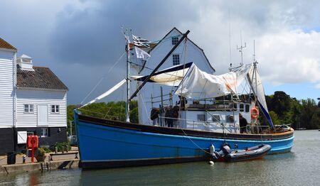 WOODBRIDGE, SUFFOLK, ENGLAND - MAY  04, 2019: Old sailing boat moored outside famous tide mill.のeditorial素材