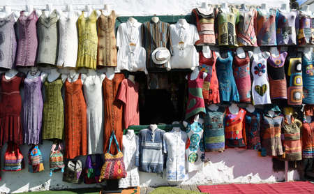 TEGUISE, LANZAROTE, SPAIN - MARCH 31, 2019:   Shopfront with colorful garments hanging on wall and mirror.のeditorial素材