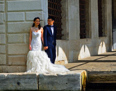 VENICE, ITALY - SEPTEMBER 25, 2017: Bride and Groom Wedding Couple posing by canal side Venice.のeditorial素材