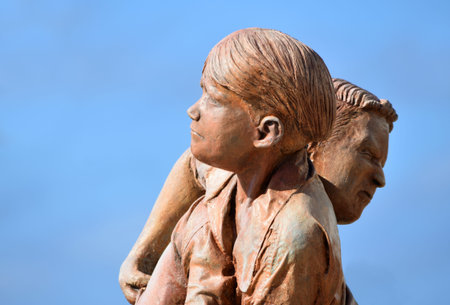 PLAYA BLANCA,  LANZAROTE, SPAIN - APRIL 04, 2019: Statue of young boys wrestling blue sky...