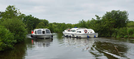 Two Broads Cruisers on the River Ant at How Hill Norfolk.のeditorial素材