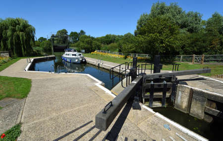 Houghton Lock on the River Ouse in Cambridgeshire with small boat moord on a sunny day.のeditorial素材