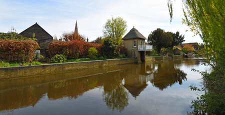 The river Ouse at Godmanchester  with old boathouse and church spire.の写真素材