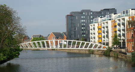 Footbridge over the River Great Ouse at Bedford with trees and modern buildings.の写真素材