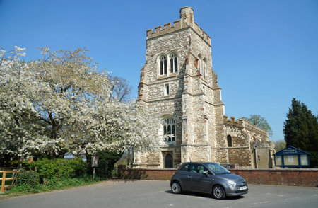 HENLOW, BEDFORDSHIRE, ENGLAND - APRIL 16, 2022: Fiat 500 parked in front of Henlow Church with tree...