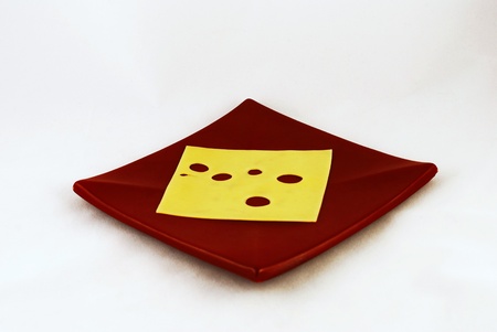 A slice of cheese on brown plateの写真素材