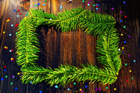 Frame of green spruce on a wooden background. Confetti.の写真素材