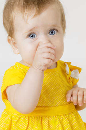 Little girl in the yellow dress on a light backgroundの写真素材