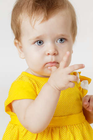 Little girl in the yellow dress on a light backgroundの写真素材