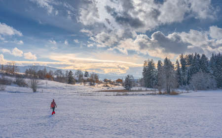 nice active senior woman snowshoeing in the Allgaeu Alps near Oberstaufen with view into the Bregenzerwald, Vorarlberg, Austriaの写真素材