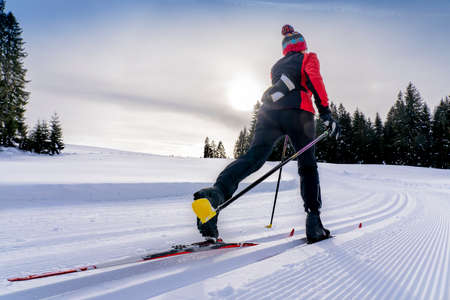 beautiful active senior woman cross-country skiing in fresh fallen powder snow in the Allgau alps near Immenstadt, Bavaria, Germanyの写真素材