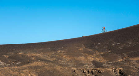 Senior man mountainbiking on volcanic trails of Lanzarote Island, Canary Islands, Spainの写真素材