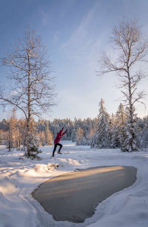 nice woman jumping from Joy in a tranquil winter landscape at sunset with fresh powder snow in the Allgaeu alps, Bavaria, Germanyの写真素材