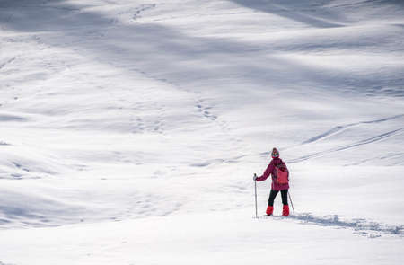 nice and active senior woman snowshoeing in deep powder snow in the Allgau alps, Bavaria, Germanyの写真素材