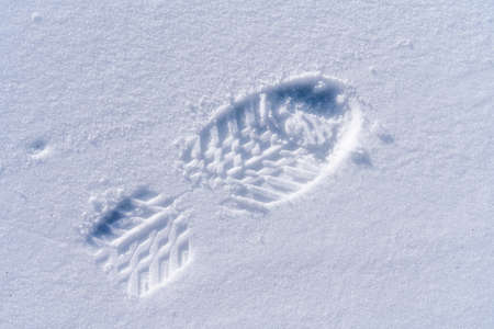 fresh footprint of a mountain boot in hard frozen snowの写真素材
