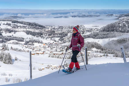 nice and active senior woman snowshoeing in deep powder snow in the Allgau alps, Bavaria, Germanyの写真素材