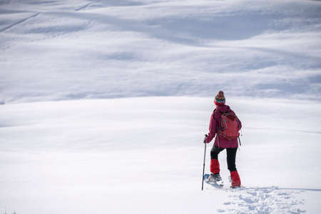 nice and active senior woman snowshoeing in deep powder snow in the Allgau alps, Bavaria, Germanyの写真素材